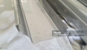 a photography of a metal door with a white cloth on it, there is a metal door with a window that has been painted silver