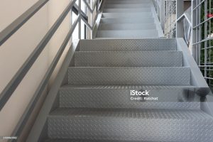 A staircase with a metal railing and a shiny, metallic surface