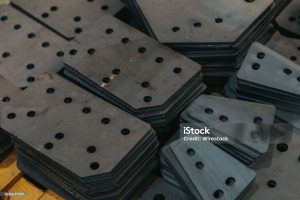 A bunch of different kinds of connecting plates stacked in neat piles